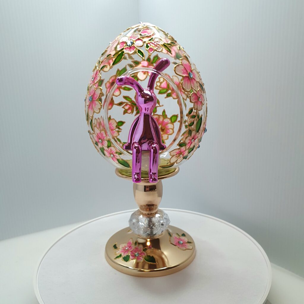 Handmade glass Easter egg on a stand with a miniature bunny inside