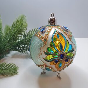 Reverse side of a turquoise and golden hand-painted Christmas ornament
