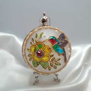 Stained glass Christmas ornament with a turquoise bird, flowers and green leaves