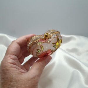 Close-up of a handmade Christmas ornament with sparkling rhinestones and a decorative cap