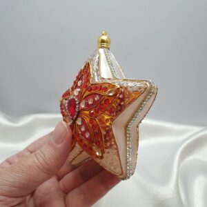 Double-sided hand-painted star ornament with red-orange stained glass-inspired pattern and sparkling details