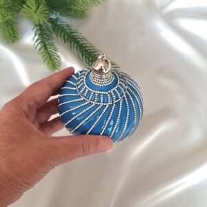 Close-up of rhinestone chains and sparkling decorative caps on spinning-top Christmas ornaments