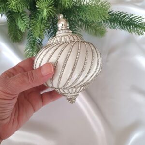 White spinning-top Christmas ornaments with rhinestone chains and silver decorative caps